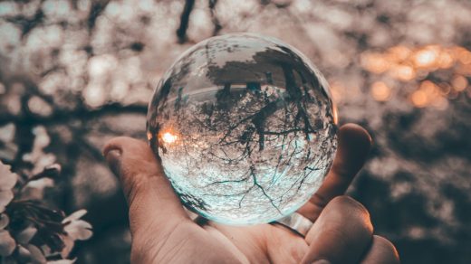 person holding round glass ball